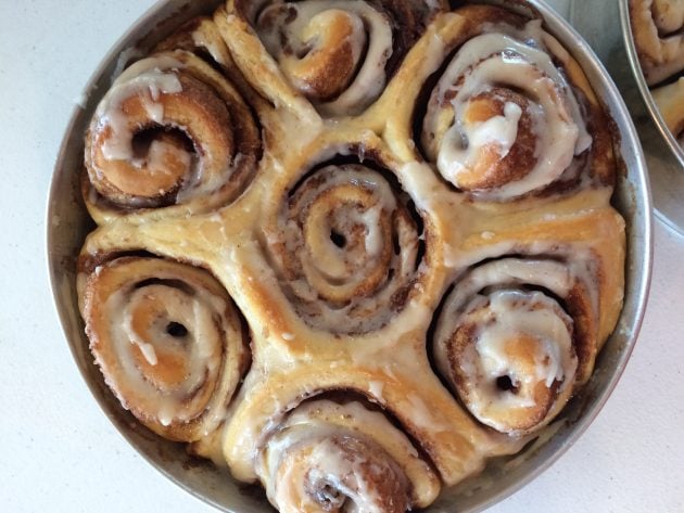 close-up of cinnamon rolls with icing in a pan