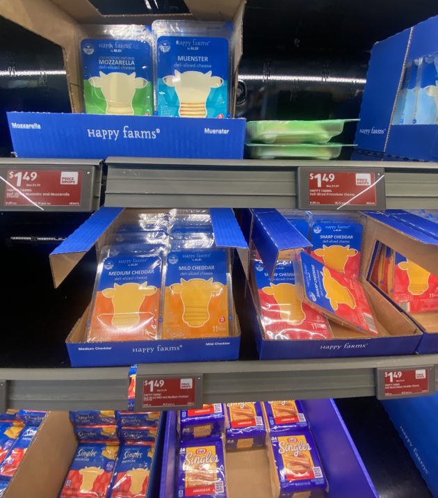 Refrigerated shelf of sliced cheeses.