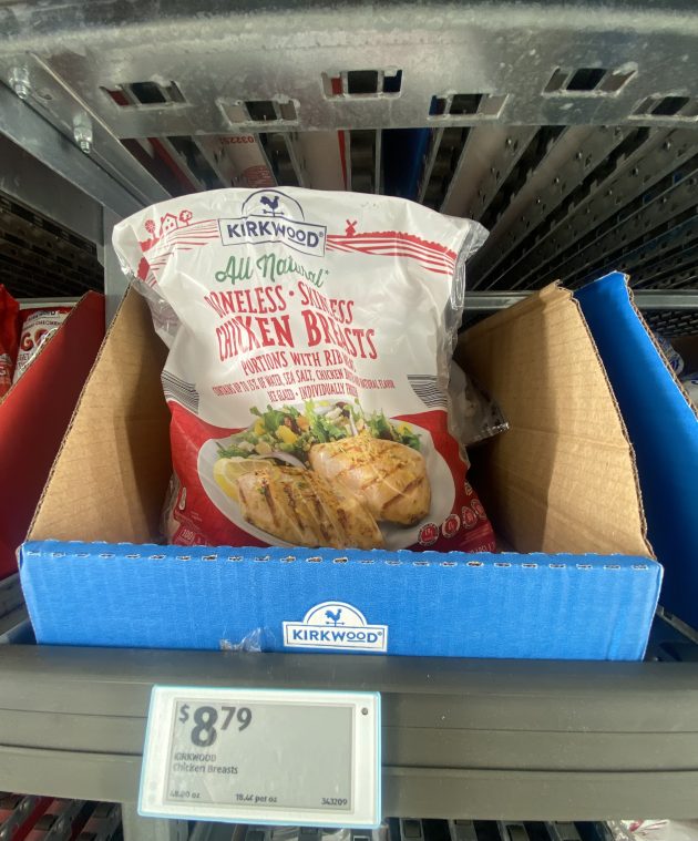 Bag labeled "Kirkwood All Natural Boneless Skinless Chicken Breasts Portions with Rib Meat" displayed in a freezer bin.