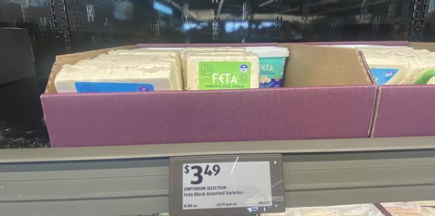 Shelf displaying blocks of cheese including feta.