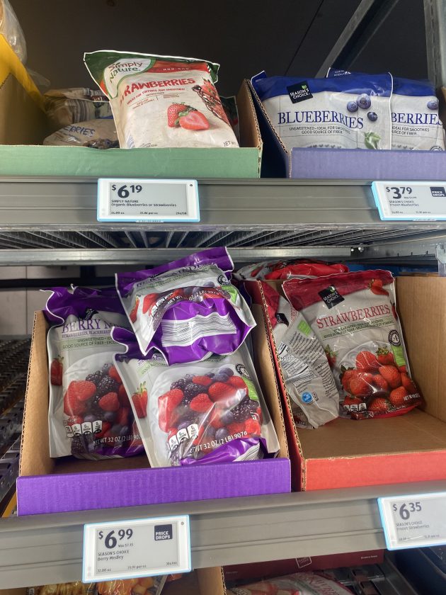 Freezer section filled with bags of frozen fruit.
