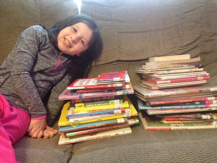 child with stacks of books