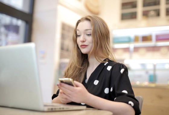 Girl on Computer and Phone With Shopping Addiction