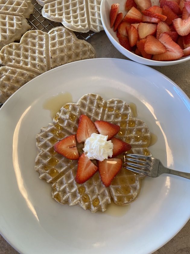 gluten-free waffles with strawberry, whipped cream, and syrup