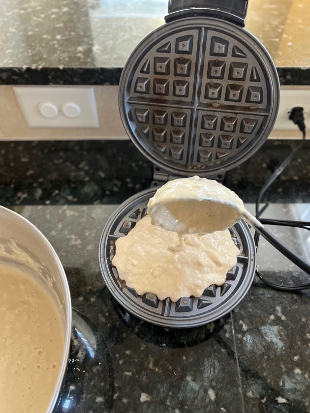 spooning batter into waffle maker