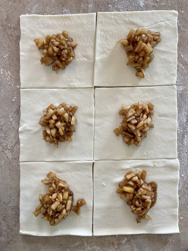 adding the apple filling to the puff pastry squares