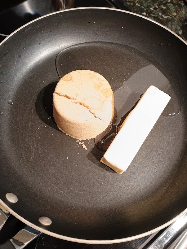 Stick of butter and packed brown sugar placed in a pan with oil.