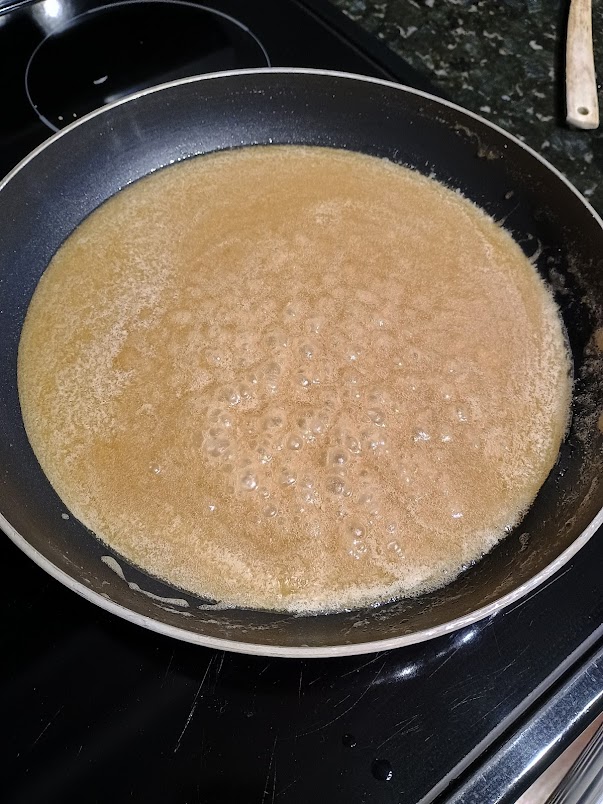 Butter and brown sugar melting together in a pan on the stove.