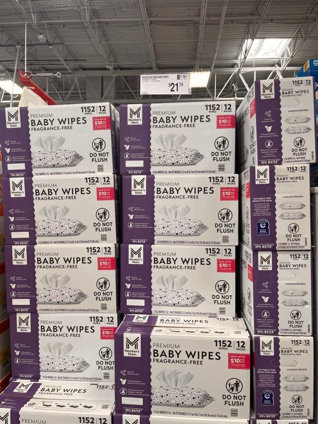 Bulk boxes labeled "PREMIUM BABY WIPES FRAGRANCE-FREE 1152 wipes 12 packs DO NOT FLUSH" stacked on a shelf.