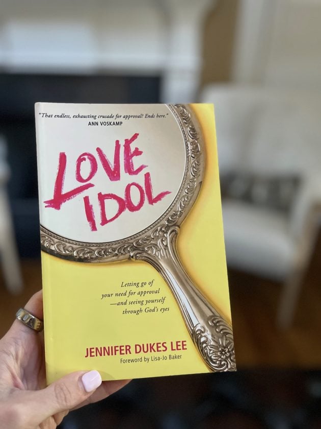 Hand holding the recommended non-fiction book "Love Idol. Letting Go of Your Need for Approval and Seeing Yourself Through God's Eyes" by Jennifer Dukes Lee.
