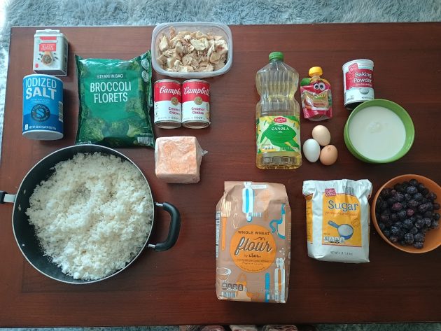Ingredients for chicken broccoli rice casserole and blueberry muffins arranged on a table.