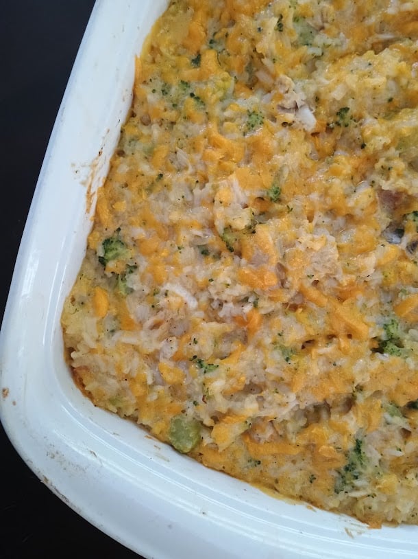 Freshly baked chicken rice broccoli casserole in a white baking dish.